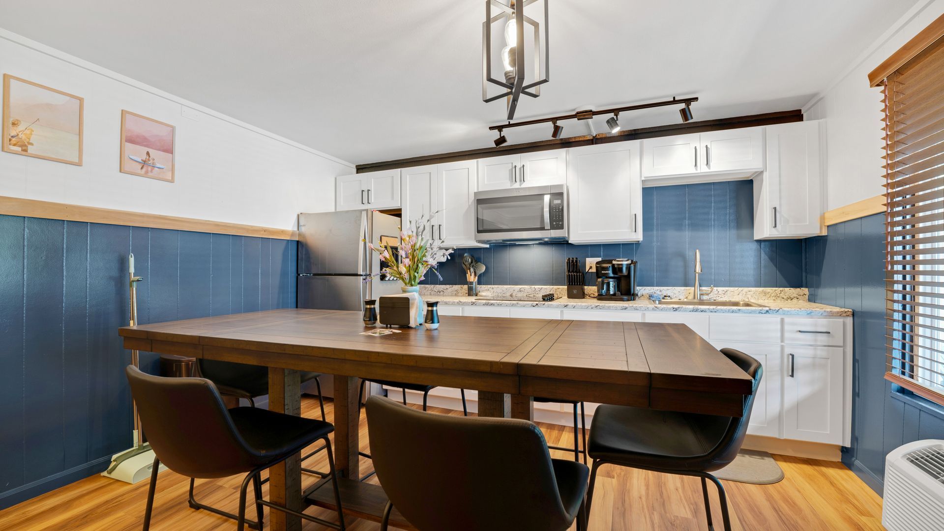 A kitchen with a wooden table and chairs in it.