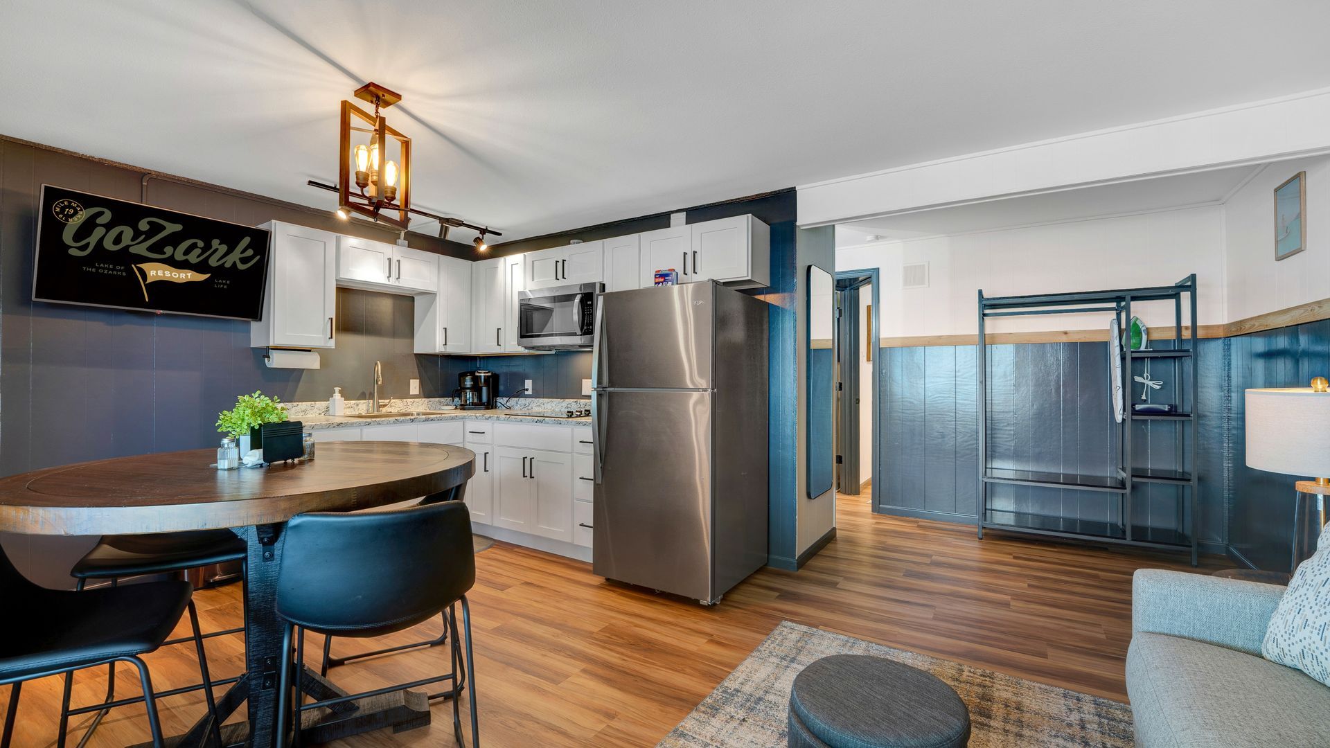 A living room with a table , chairs , and a refrigerator.