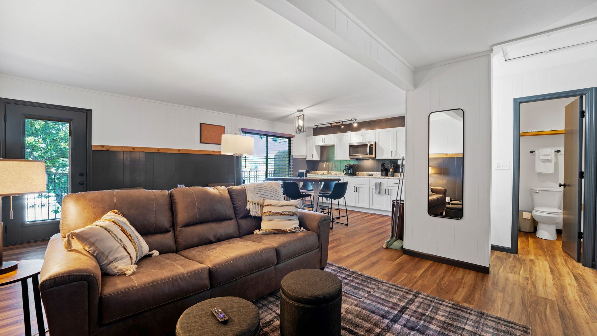 A living room with a couch , coffee table , and mirror.