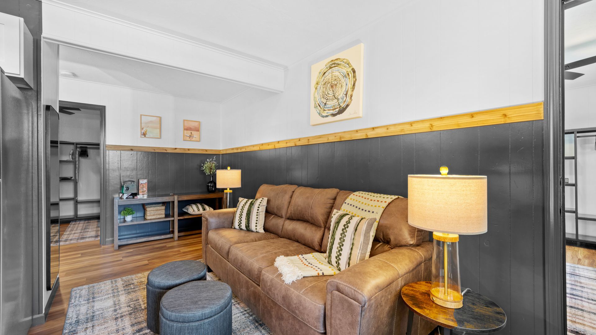 A living room with a brown couch and two lamps.