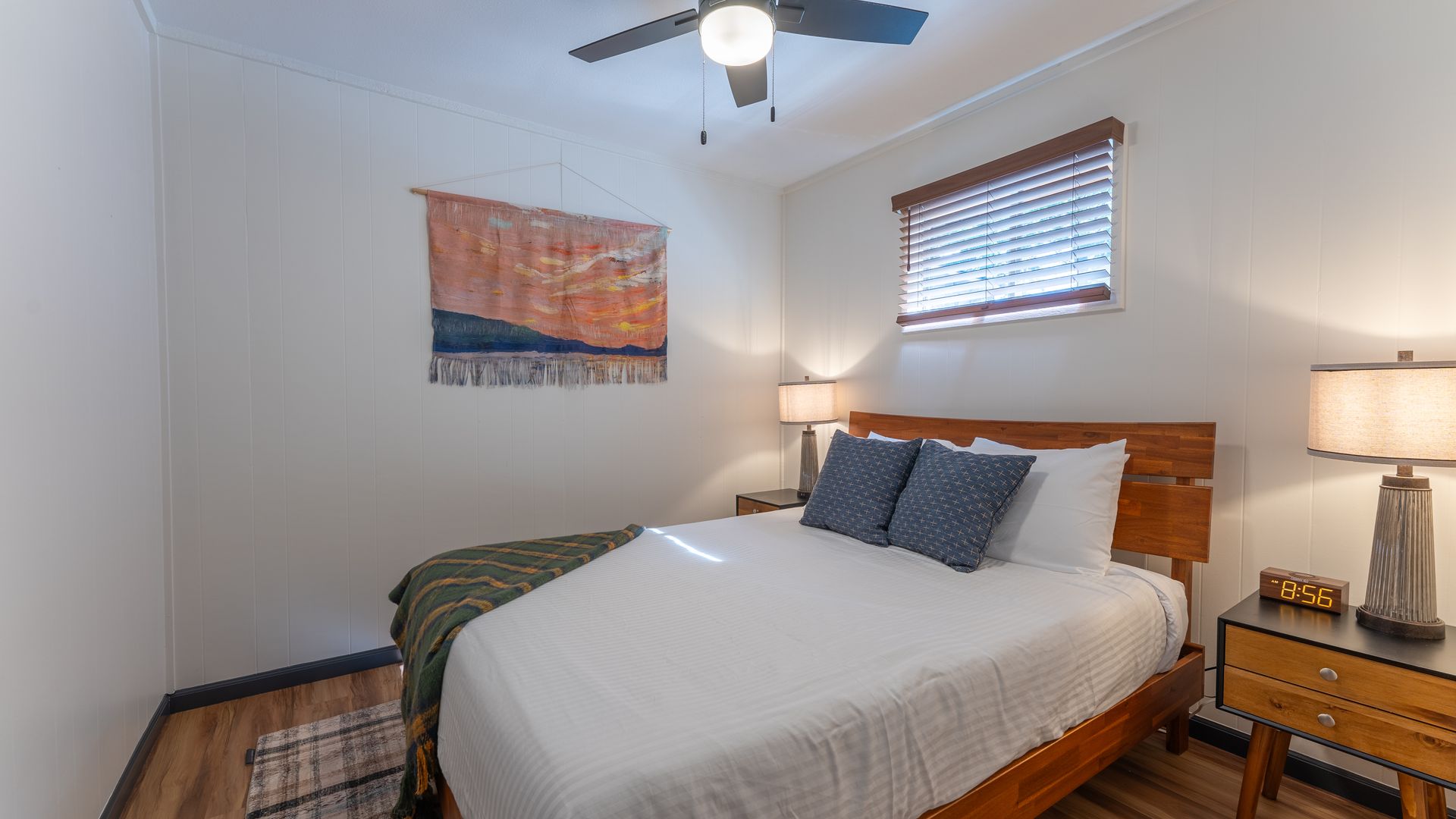 A bedroom with a king size bed and a ceiling fan.