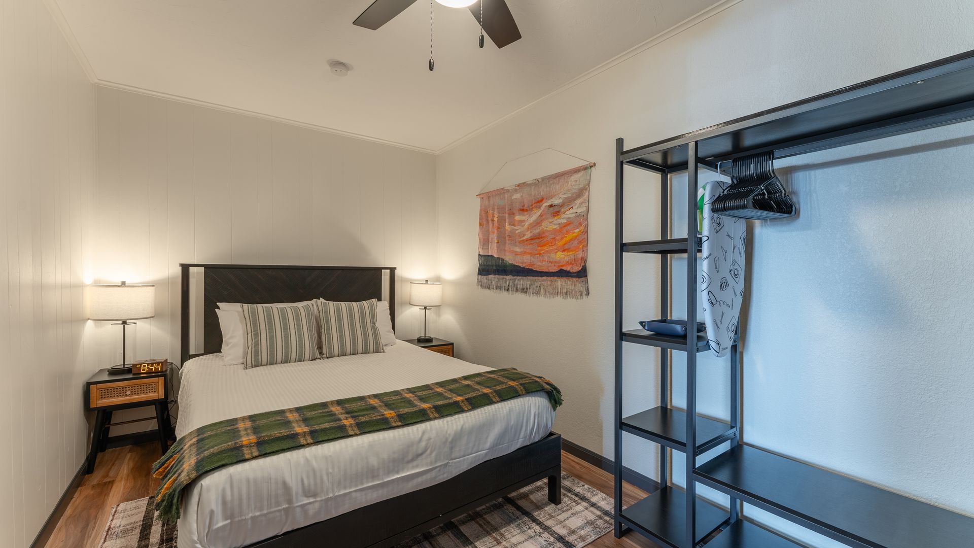 A bedroom with a king size bed , a ceiling fan , and a closet.