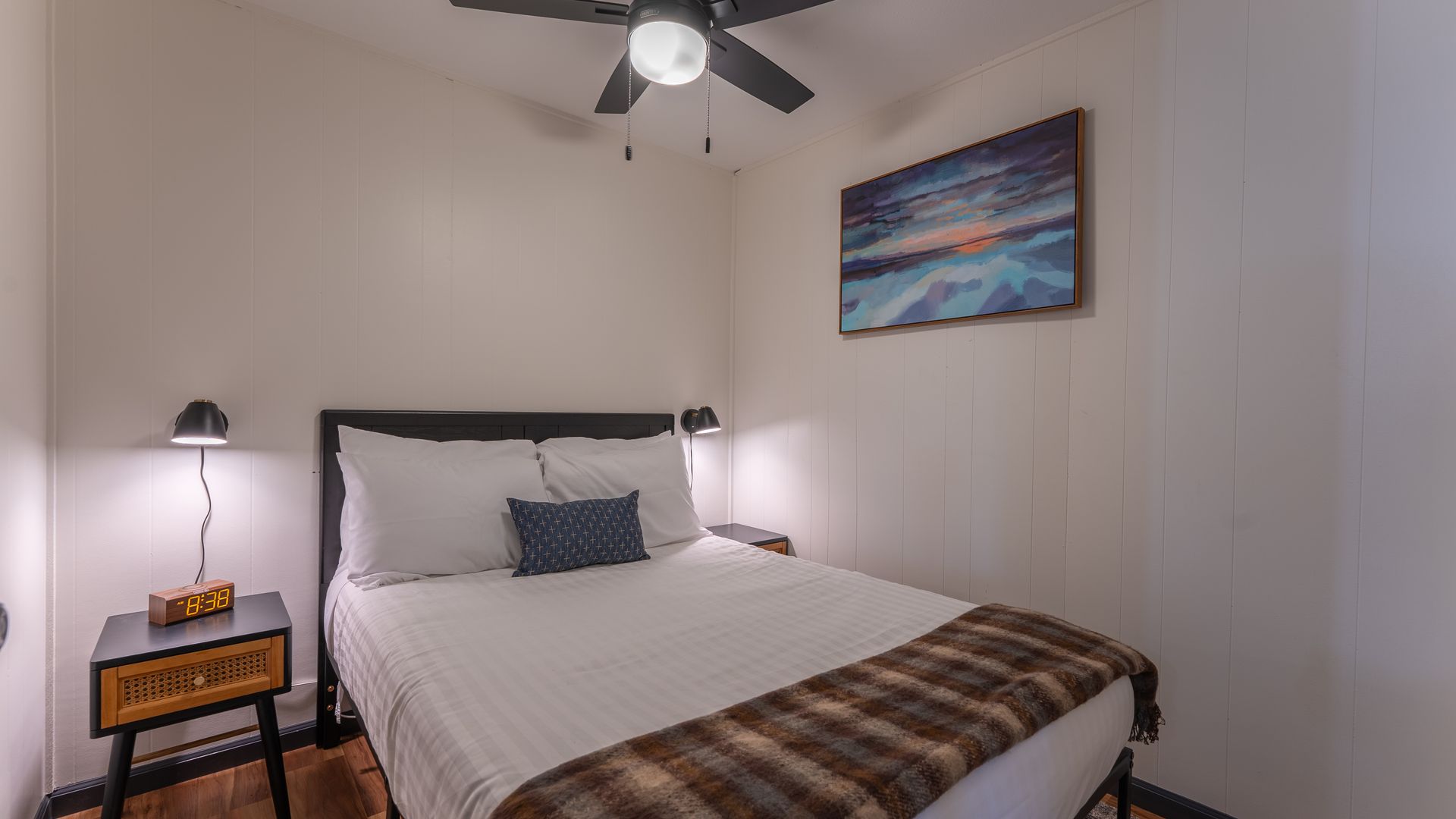 A bedroom with a bed , nightstand , and ceiling fan.