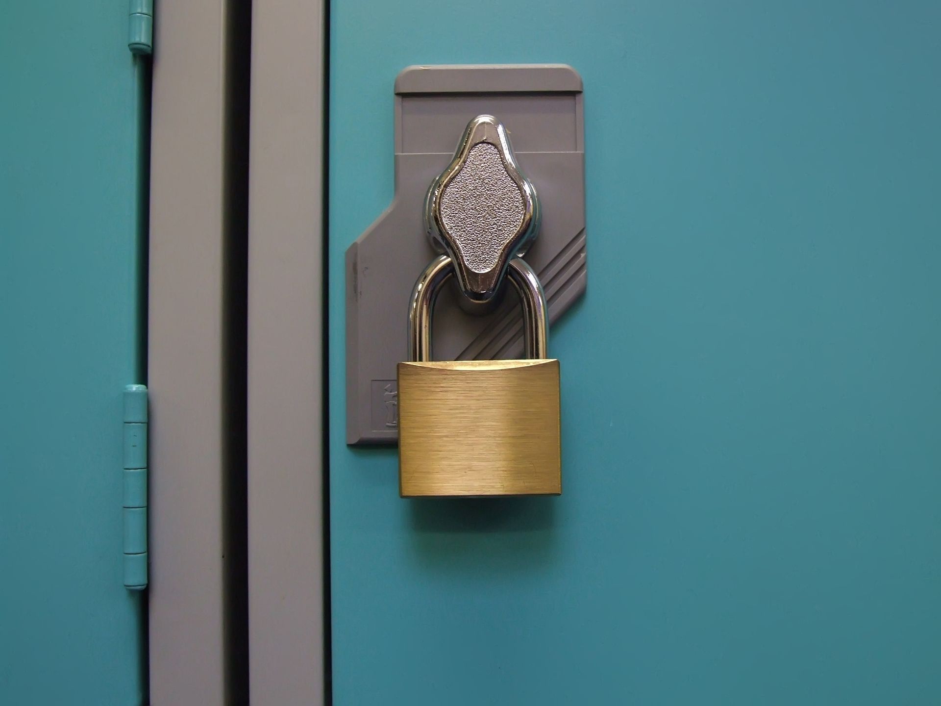 Un cadenas est accroché à la porte d'un casier bleu.