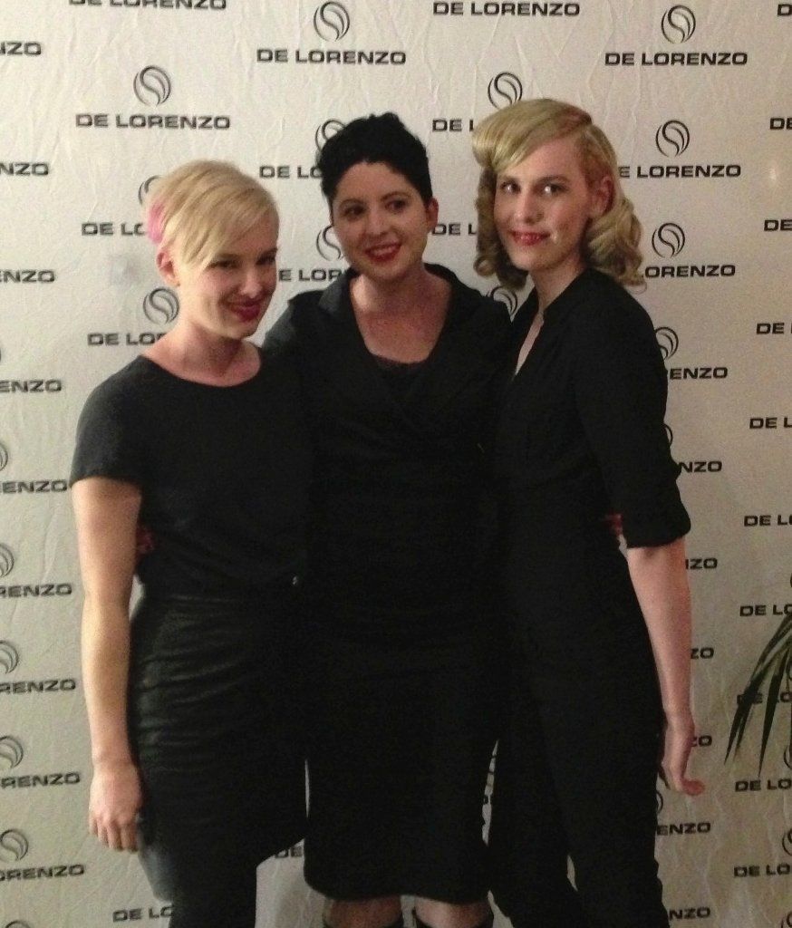 Three women standing in front of a wall that says lorenzo