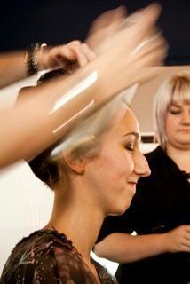 A woman is getting her hair done by a hairdresser.