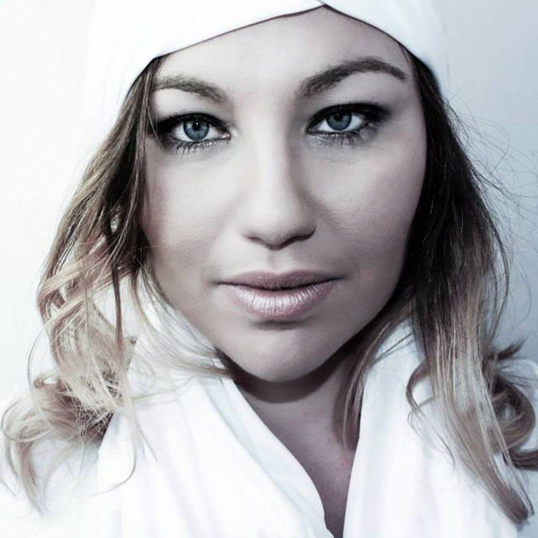 A close up of a woman wearing a white hat