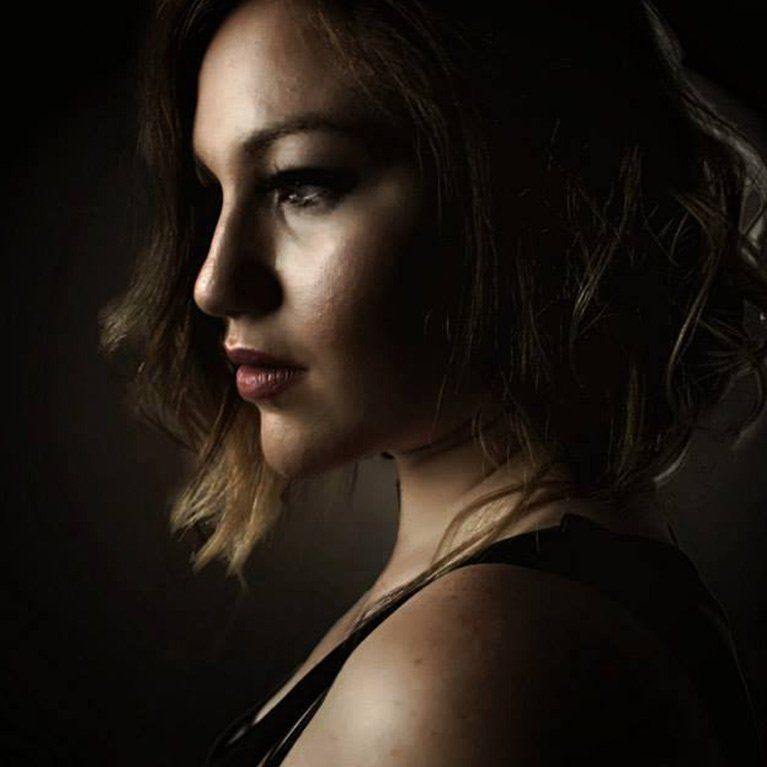 A close up of a woman 's face in the dark.