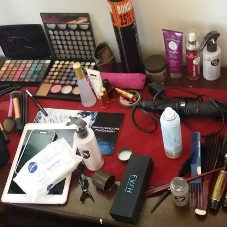 A table filled with lots of makeup including a box that says fhvh