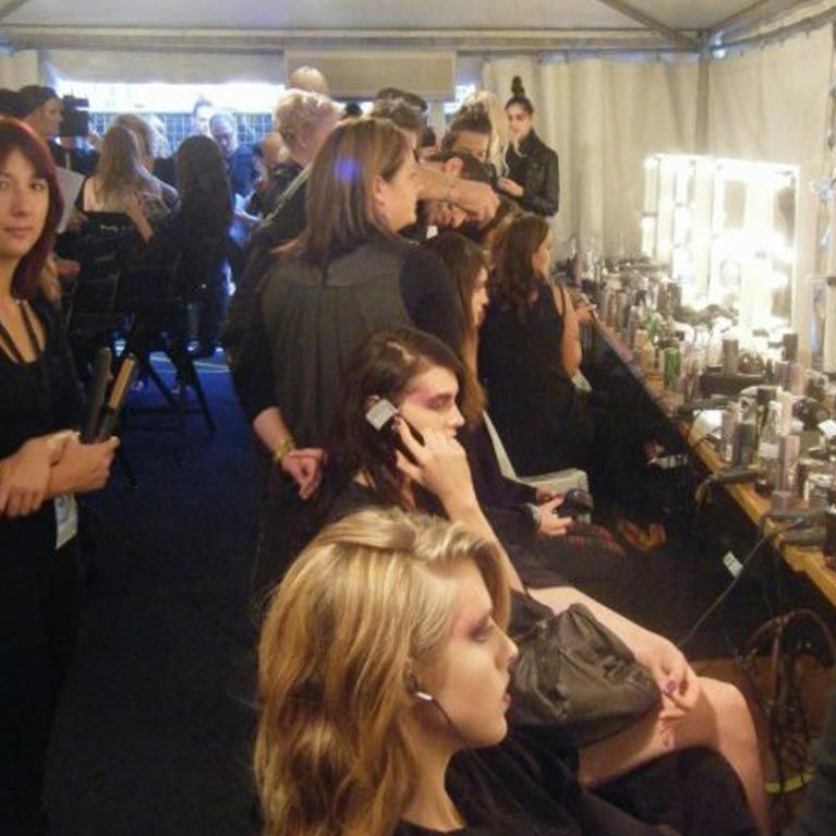 A group of women are getting their hair done in a dressing room