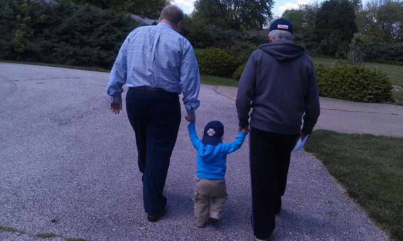 Two Men Walking A Kid