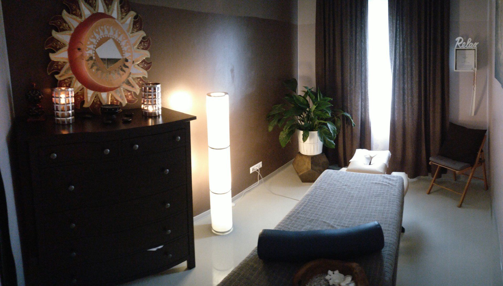 Ein Raum mit einem Massagetisch und einem Spiegel an der Wand