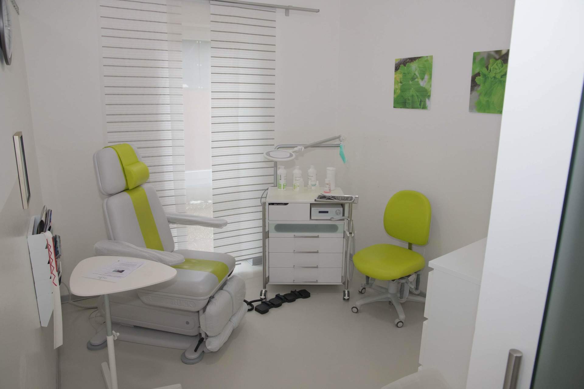 Ein weißer Raum mit einem grünen Stuhl und einem Tisch