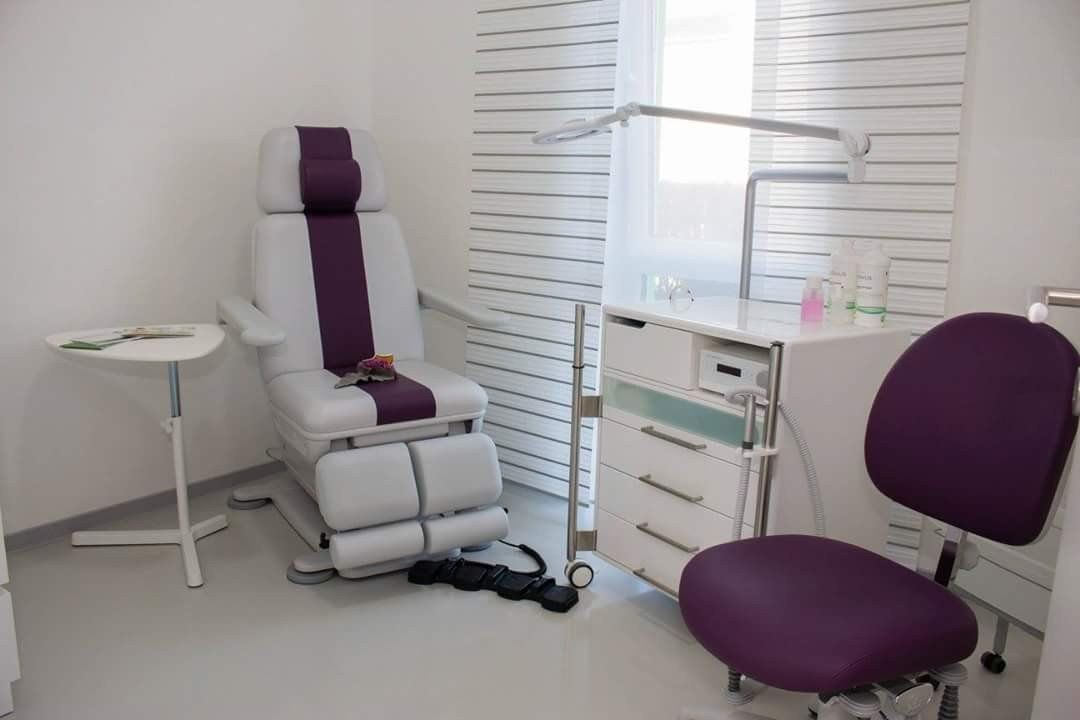 Ein Zimmer mit einem lila Stuhl und einem weißen Stuhl