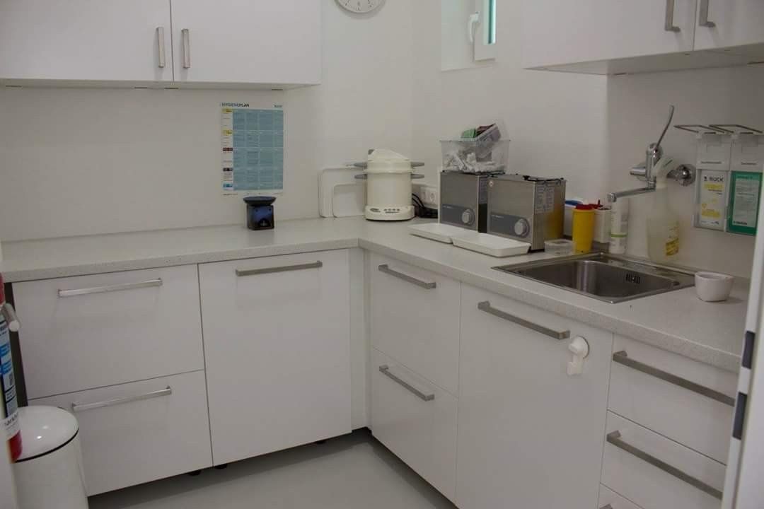 Eine Küche mit weißen Schränken und einer Spüle.