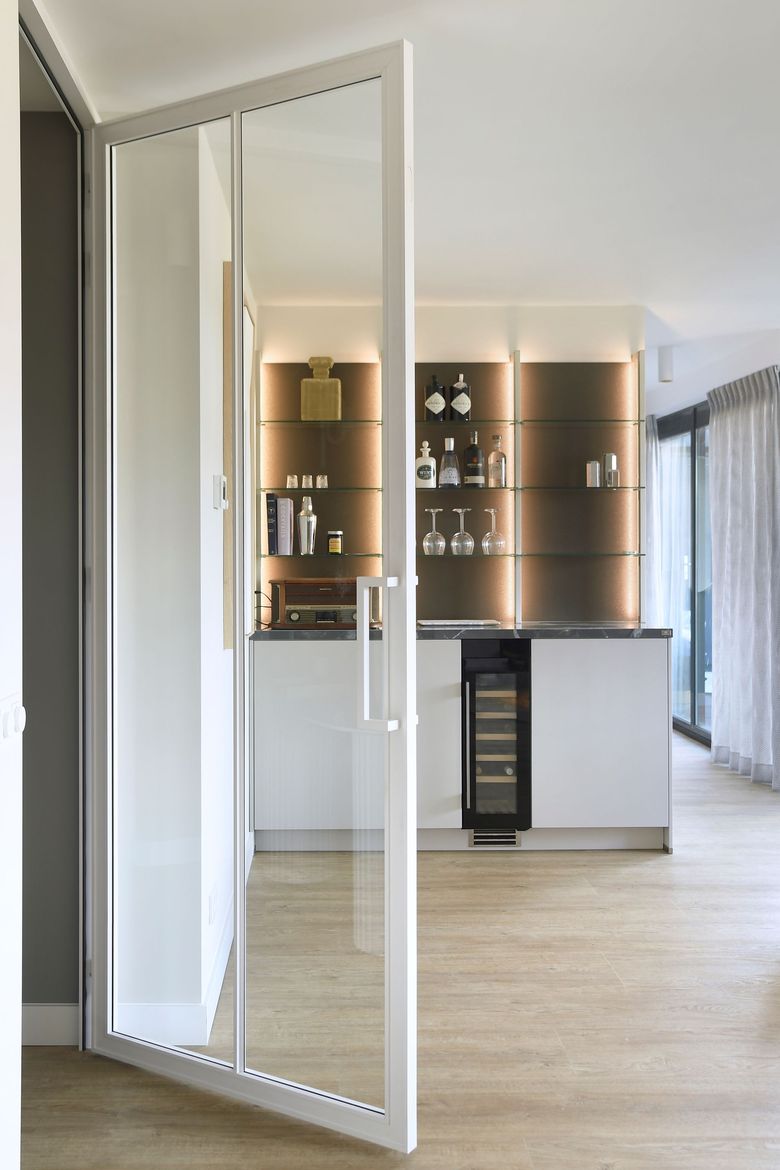 Een keuken met een groot eiland en drie krukken.