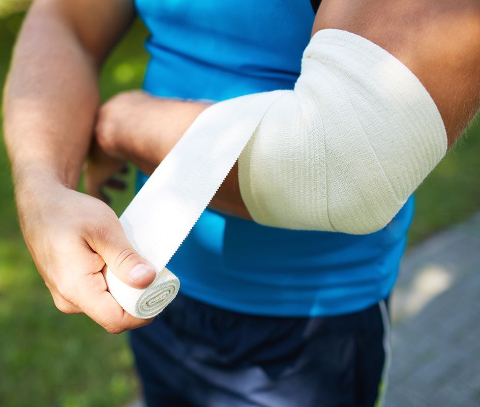 Man Bandaging His Arm