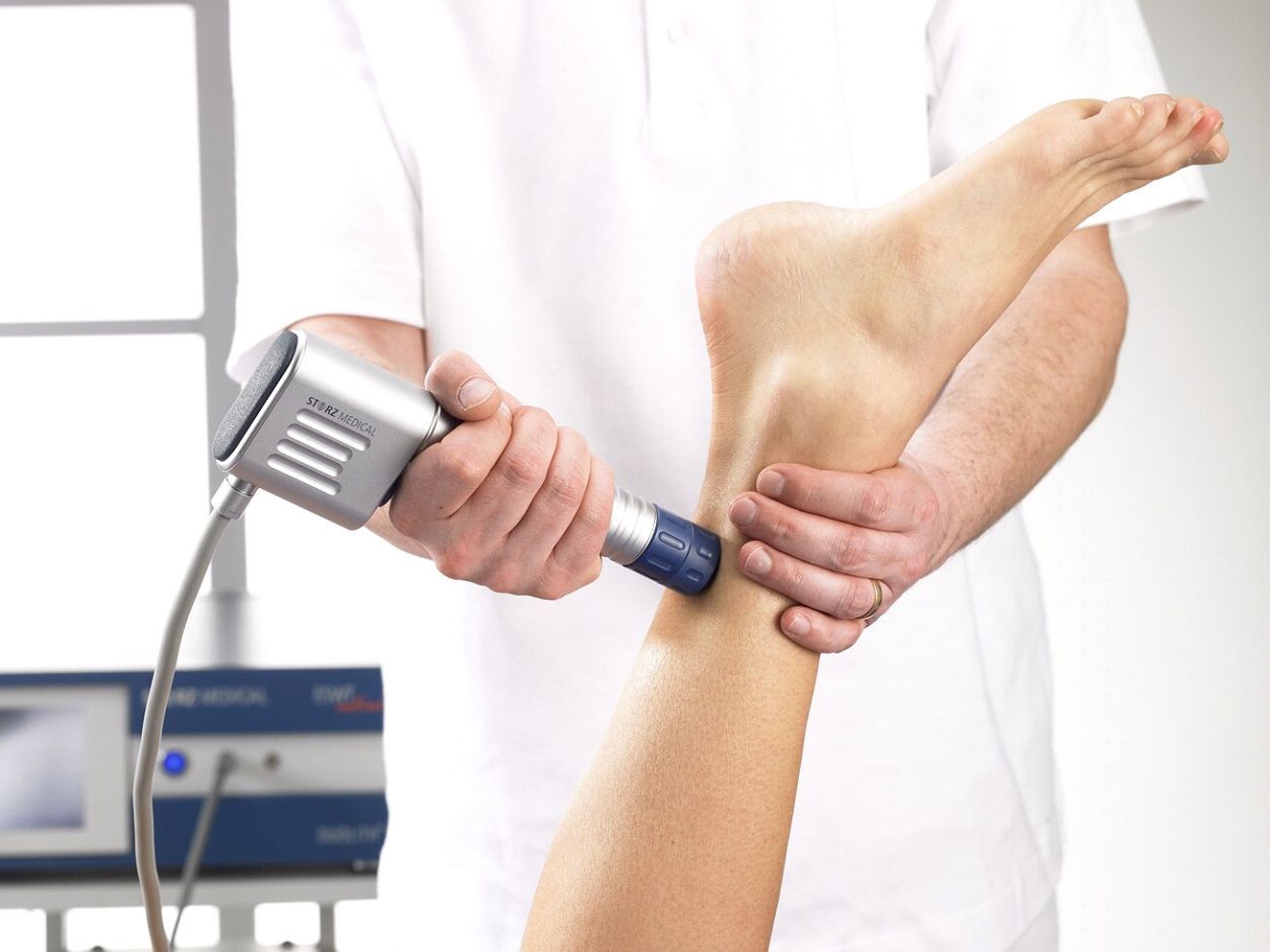 A person is getting a massage on their ankle with a machine