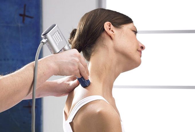 A woman is getting a massage on her neck by a doctor.