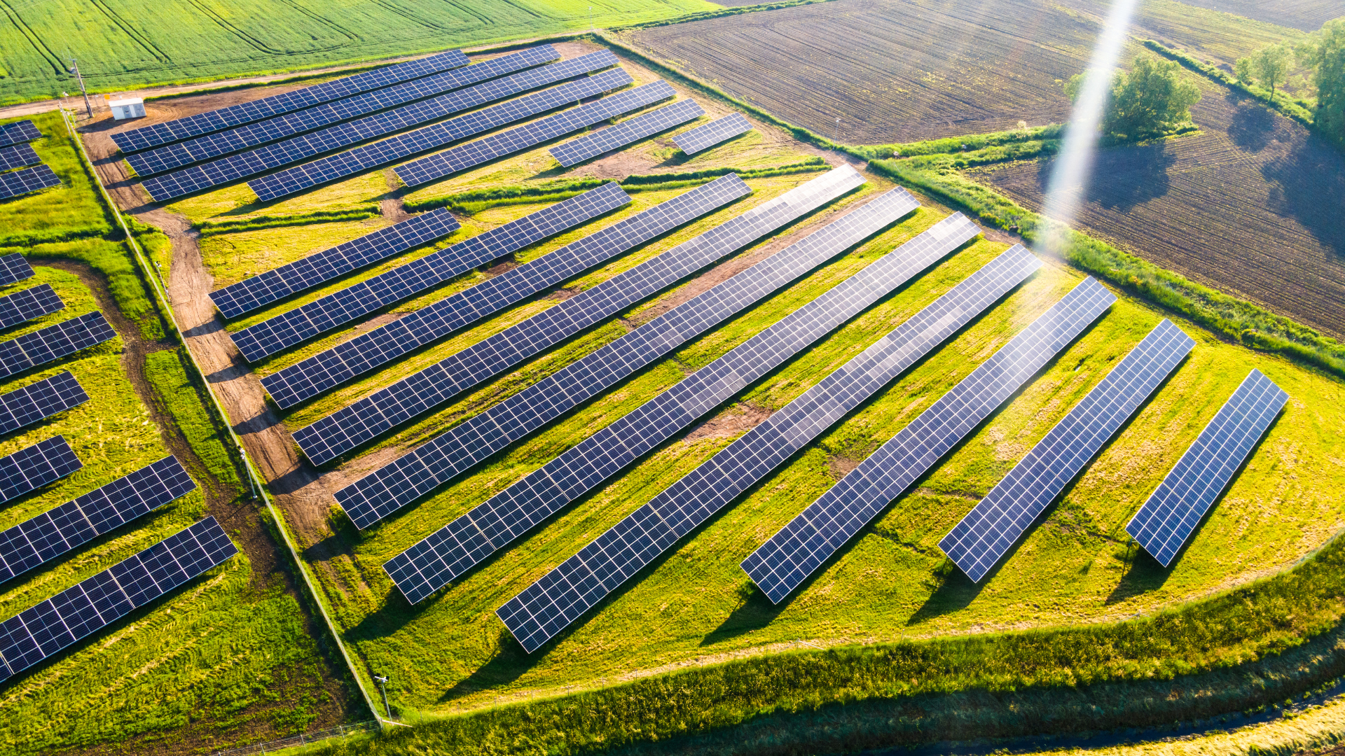 An aerial view of a row of solar panels in a field.