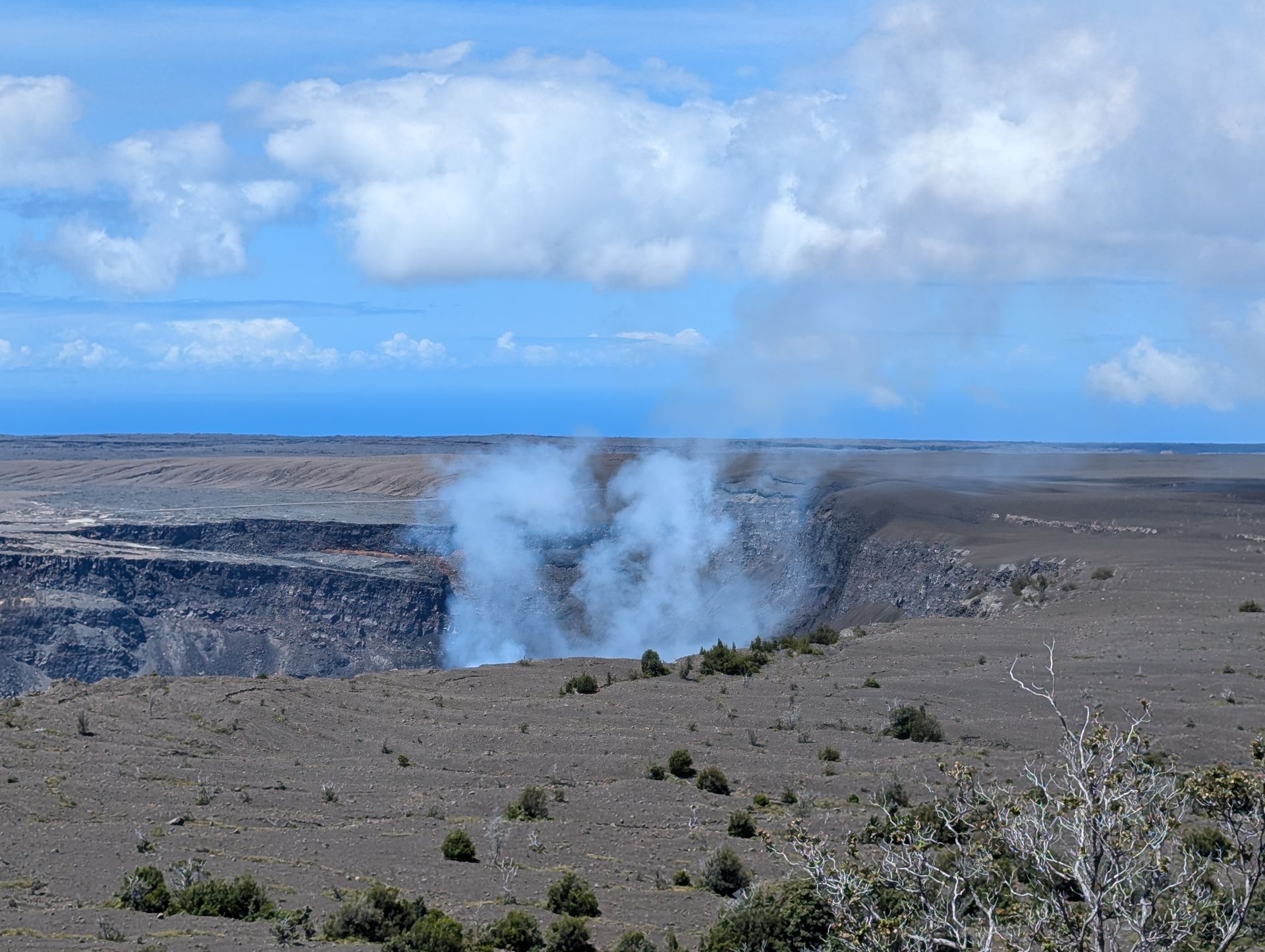 A view of a volcano with smoke coming out of it.