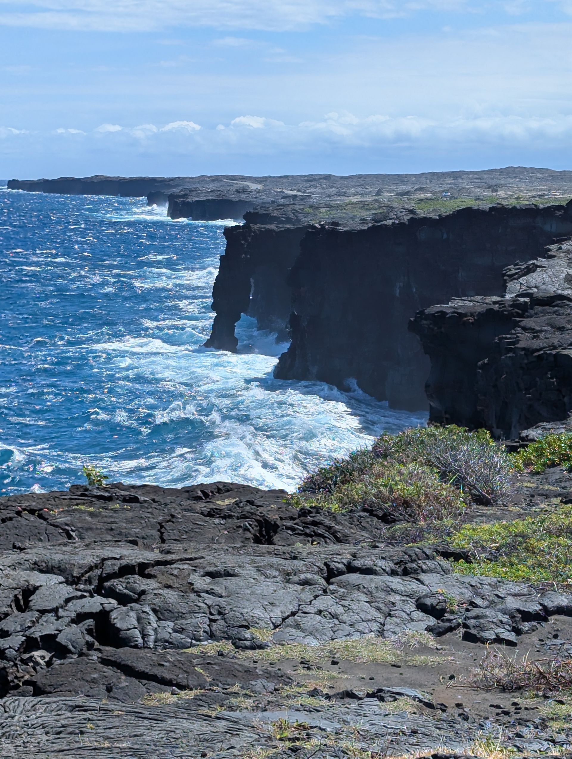 A cliff overlooking the ocean with waves crashing against it
