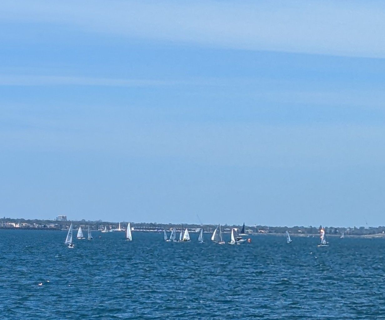 Two kayaks on a calm lake, with mountains and cloudy sky in the background.
