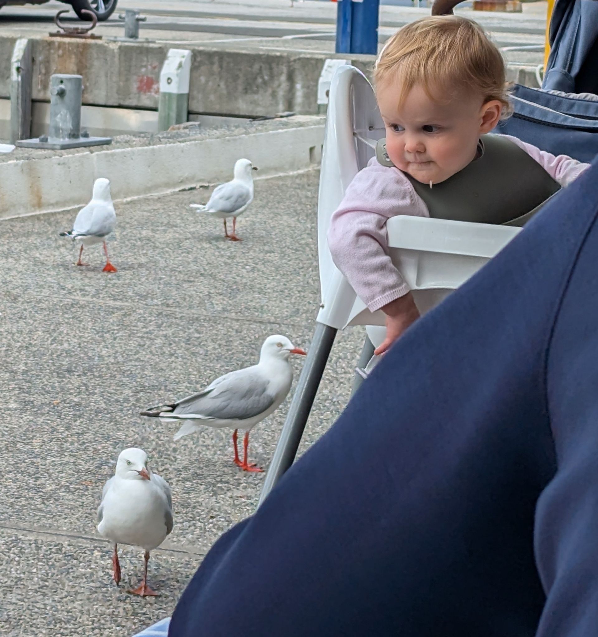 Two people paddle a wooden boat on a body of water.