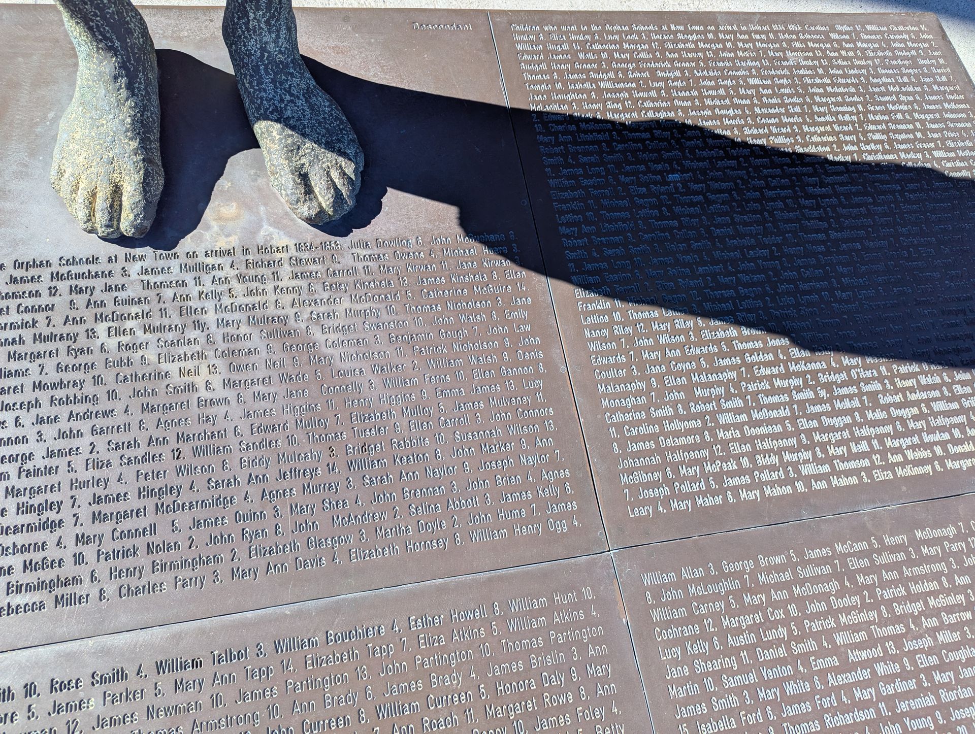 Two people paddle a wooden boat on a body of water.