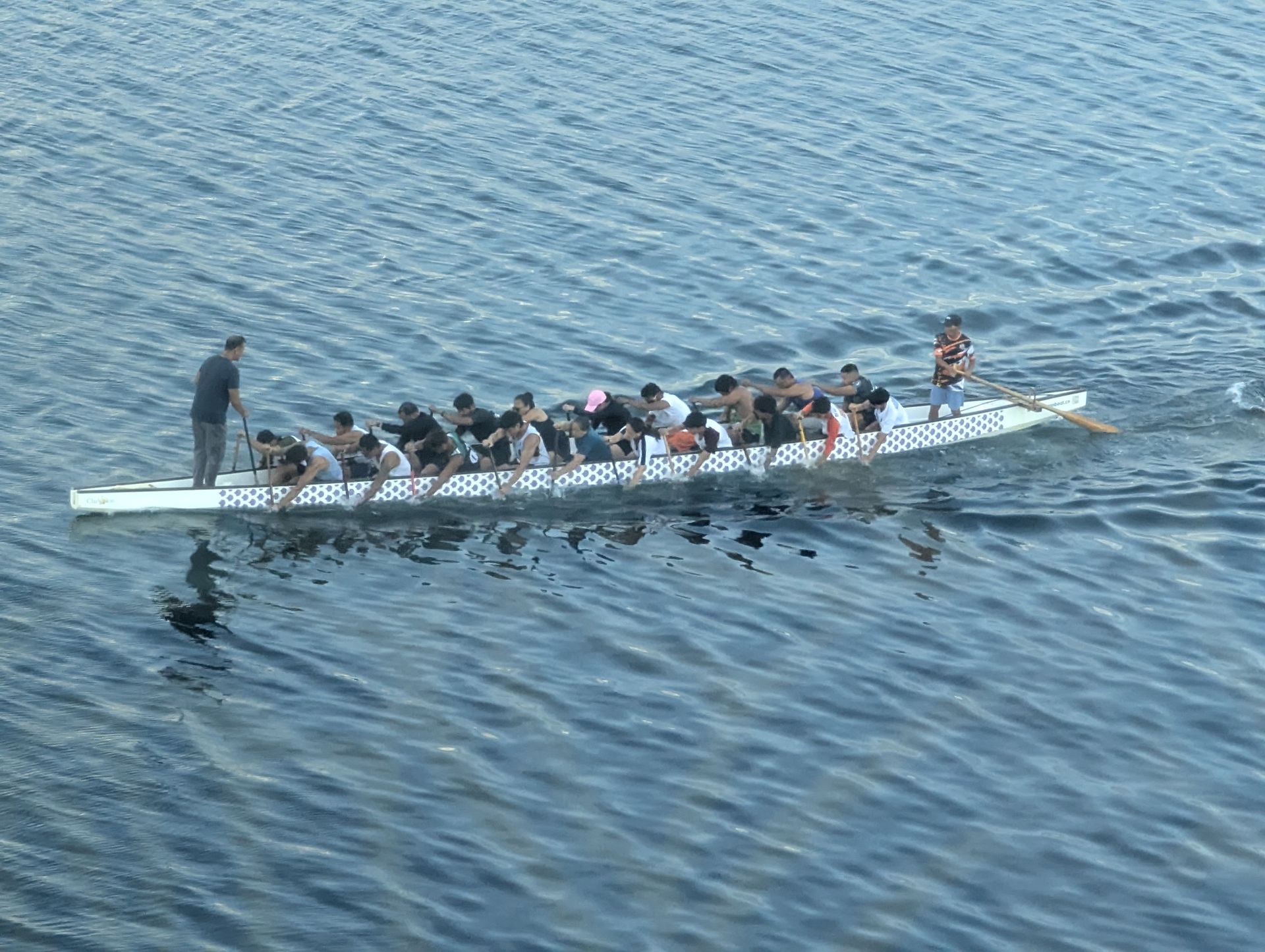 Dark, stormy sky over a body of water with mountains in the background and a ship.