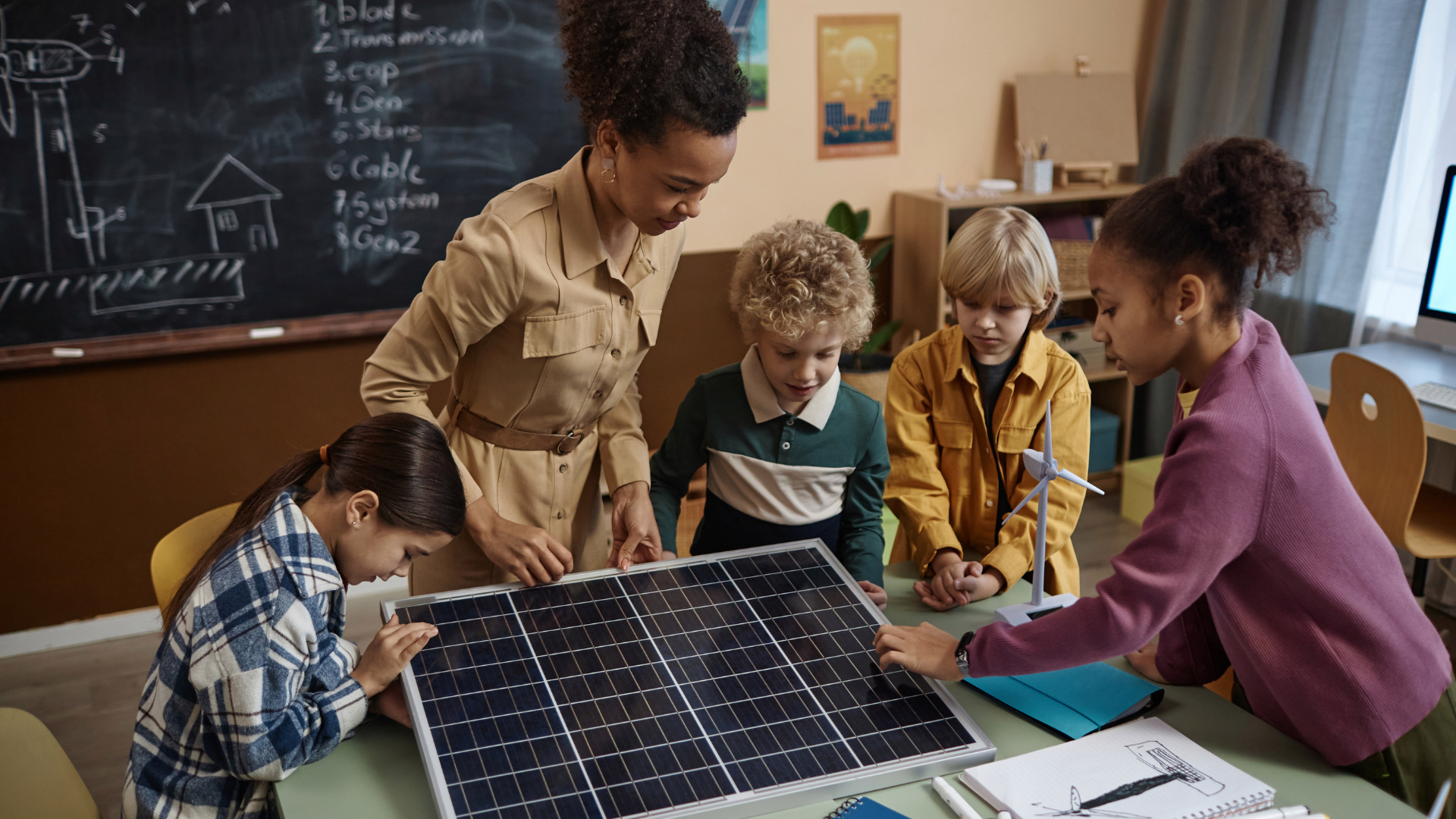 A group of children are looking at a solar panel in a classroom.