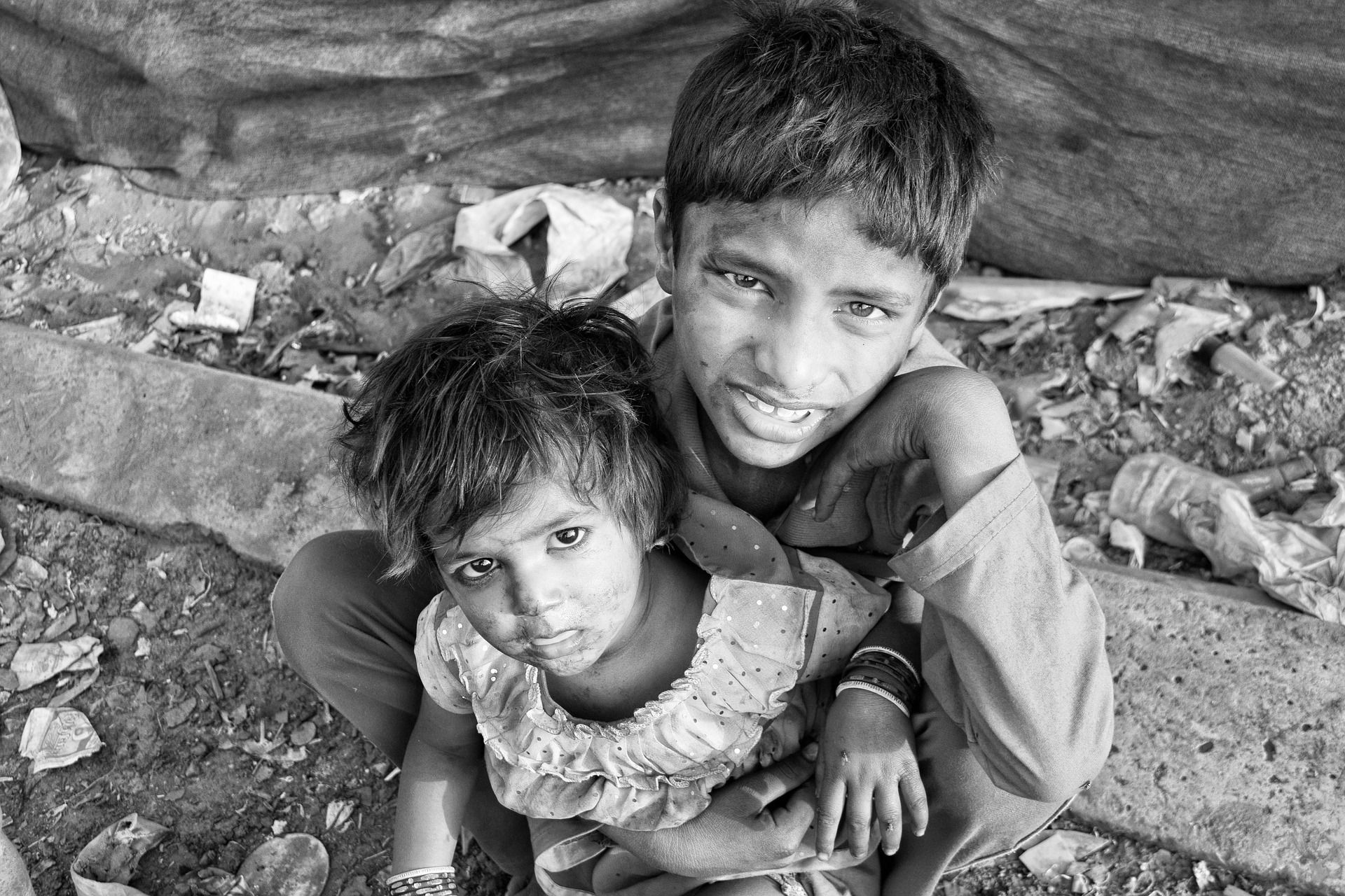 A boy is holding a little girl on his shoulders in a black and white photo.