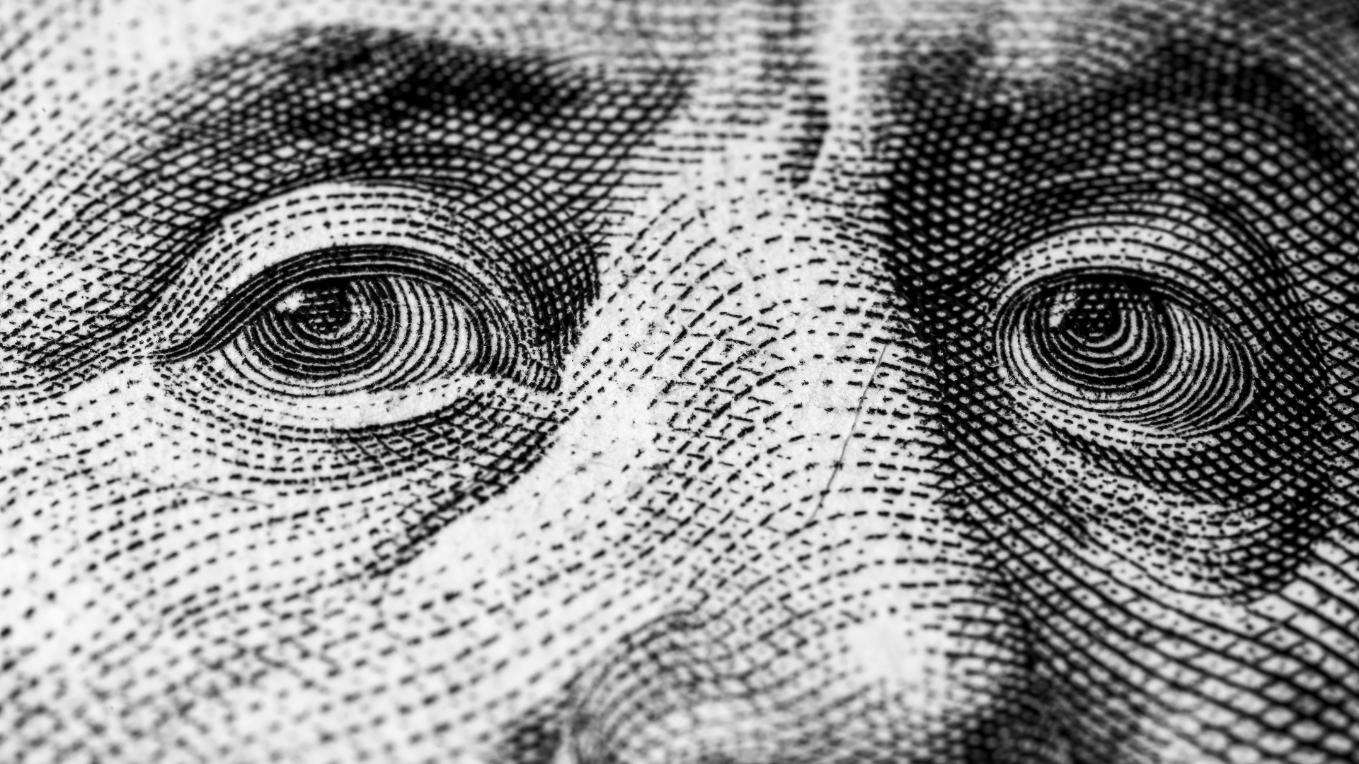 A close up of a man 's eyes on a dollar bill.