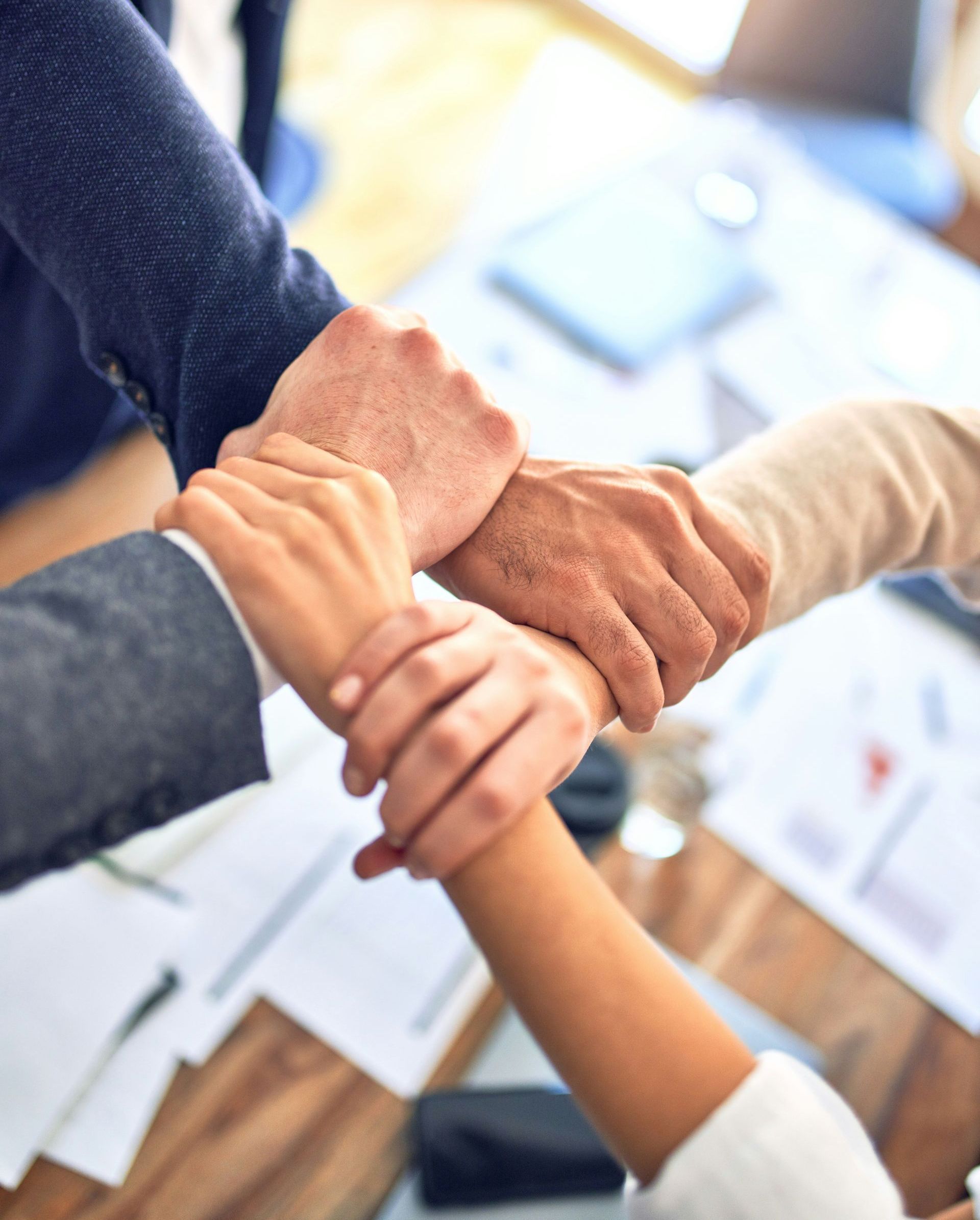 A group of people are putting their hands together.