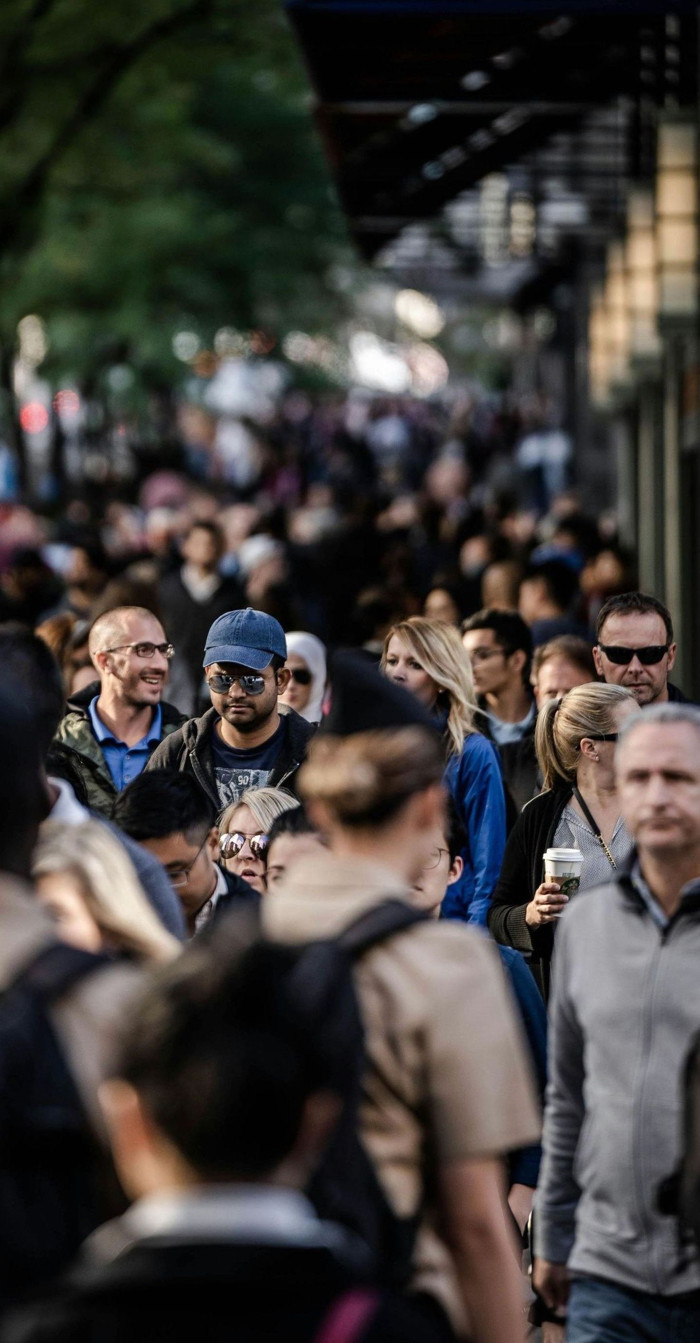 A crowd of people are walking down a city street.