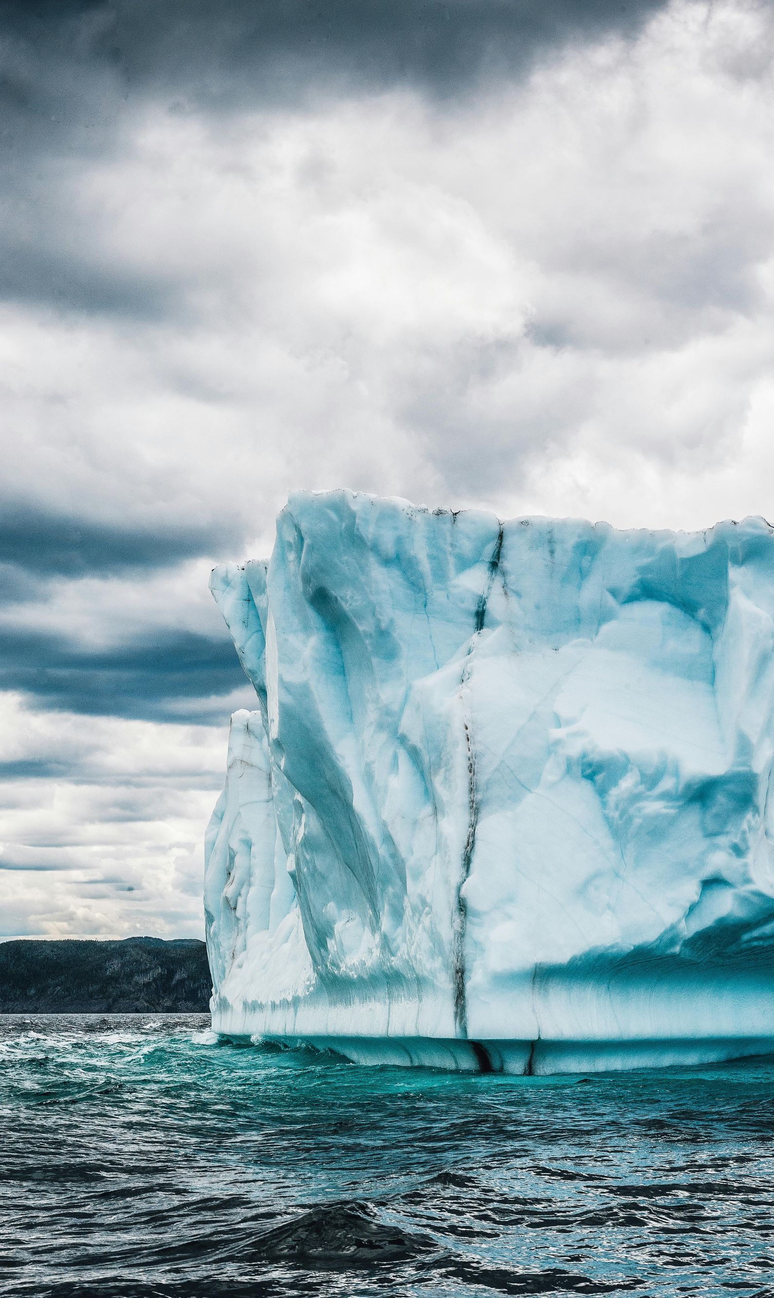 A large iceberg is floating on top of a body of water.