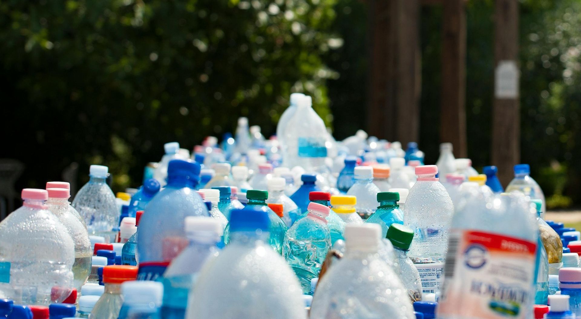 A bunch of plastic bottles are sitting on top of each other on a table.