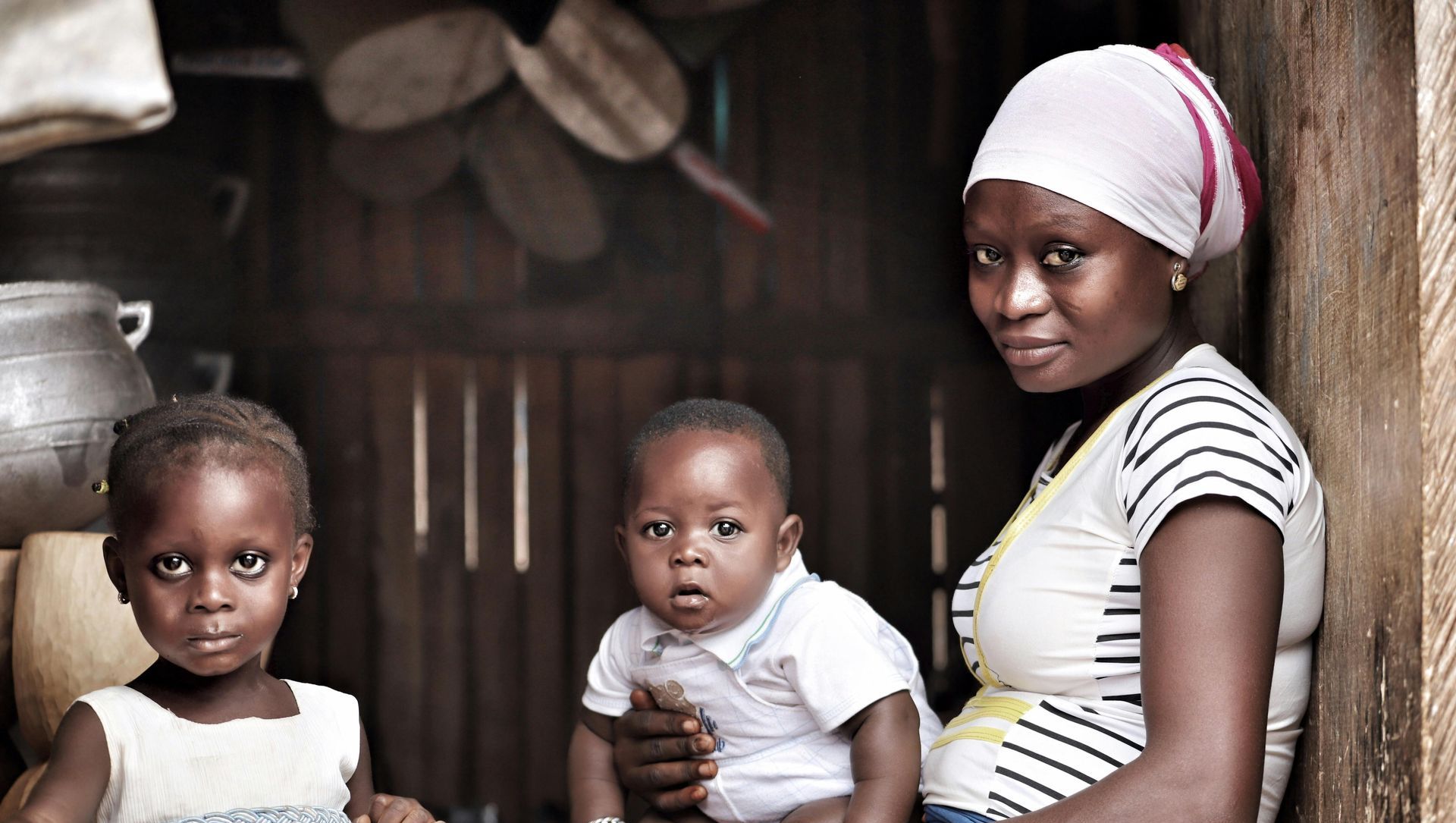 A woman is holding a baby and a little girl