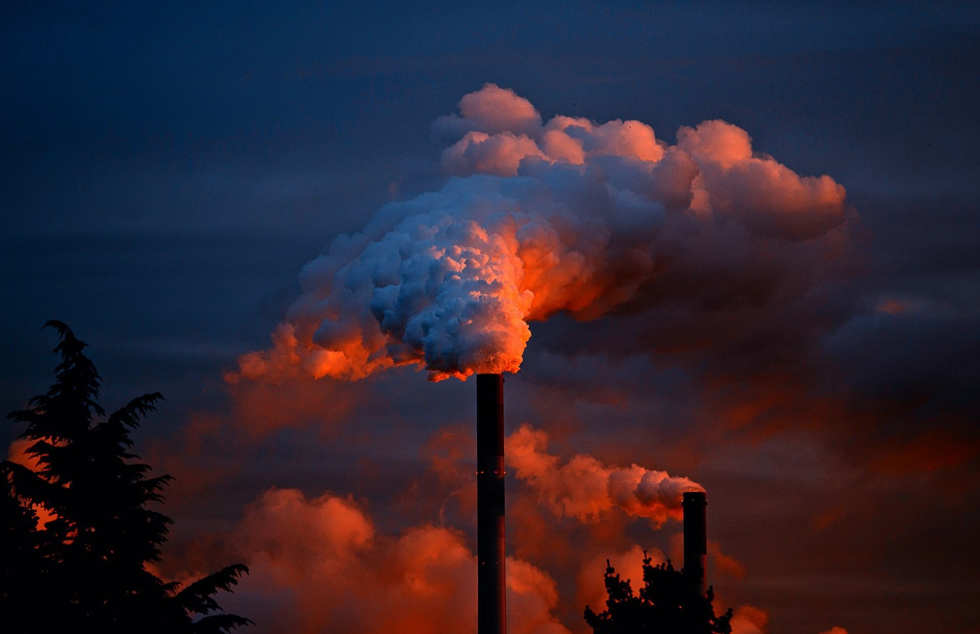 Smoke is coming out of a chimney at sunset.