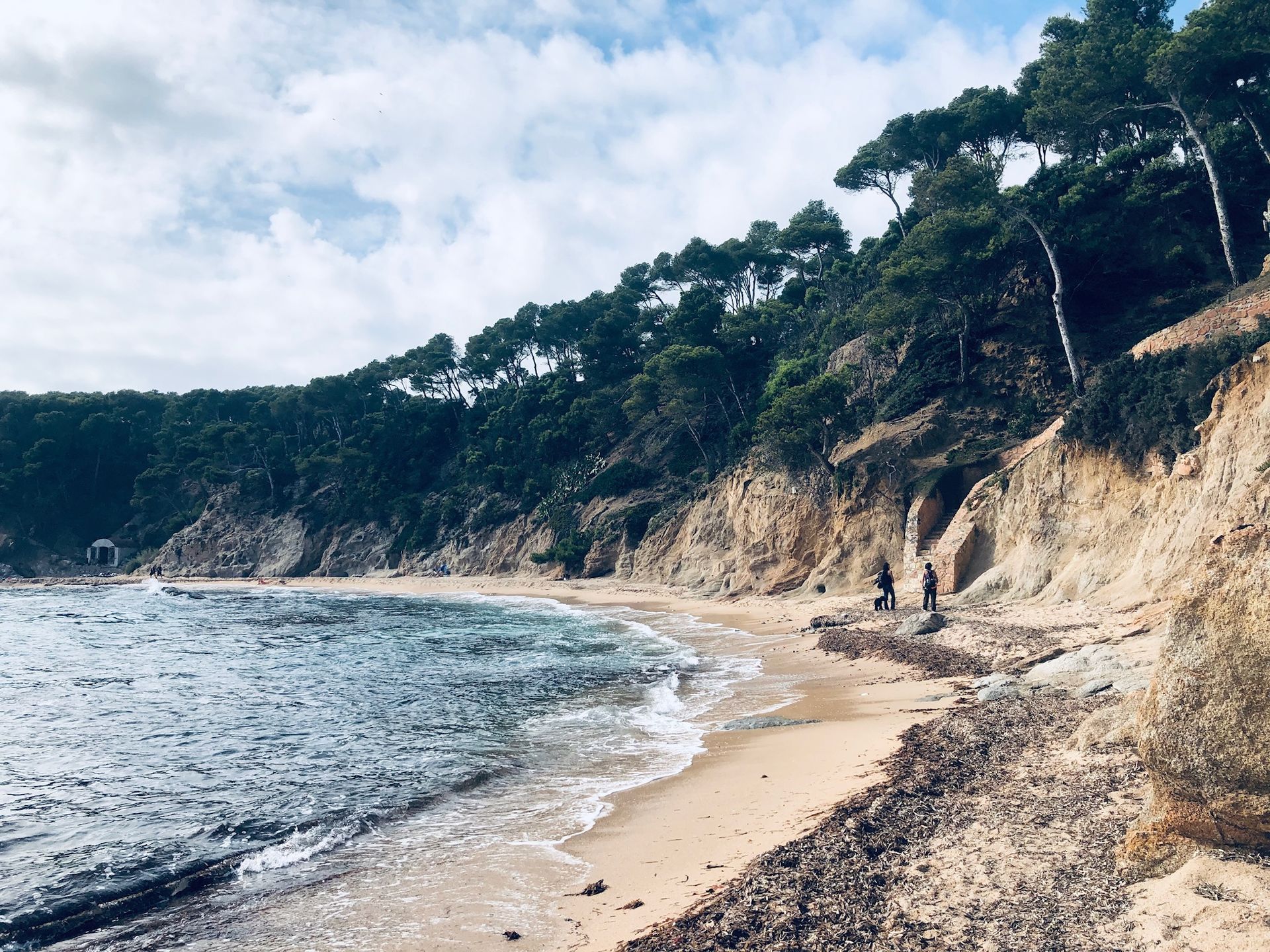 A couple of people standing on a beach next to a body of water