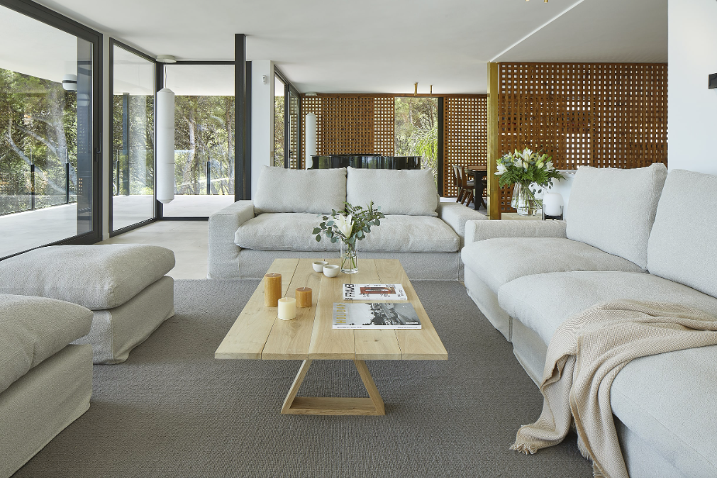A living room with white couches and a wooden coffee table
