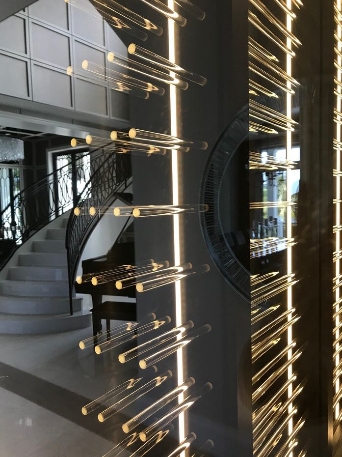 A staircase in a house with a piano and a wine rack