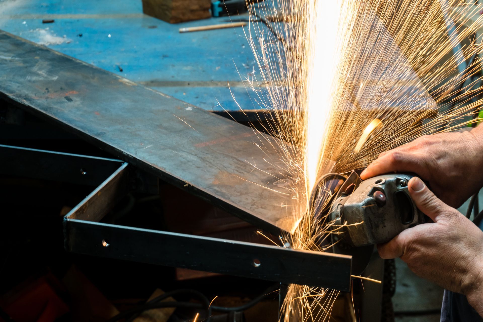 A person is grinding a piece of metal with a grinder.