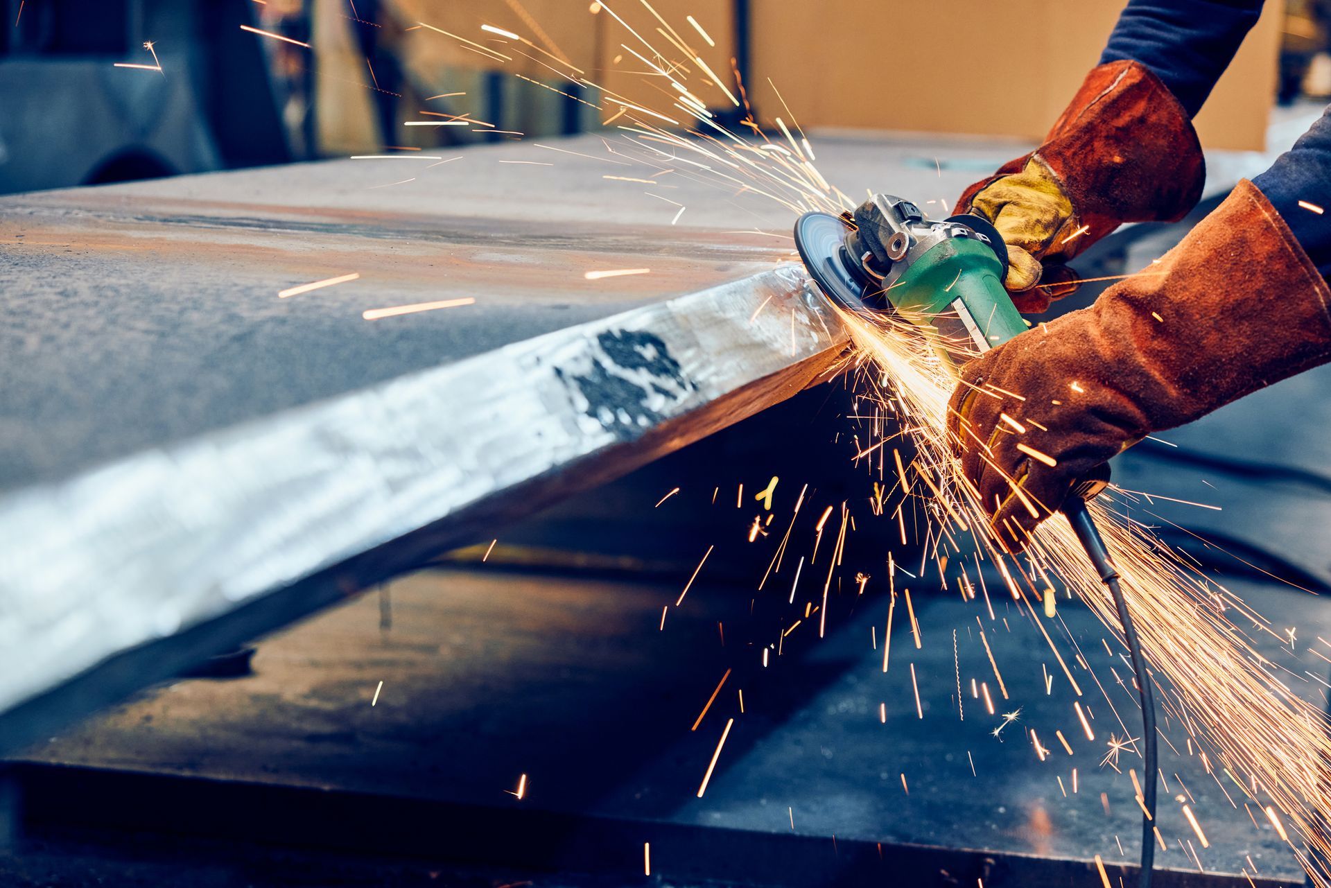 A person is using a grinder to cut a piece of metal.