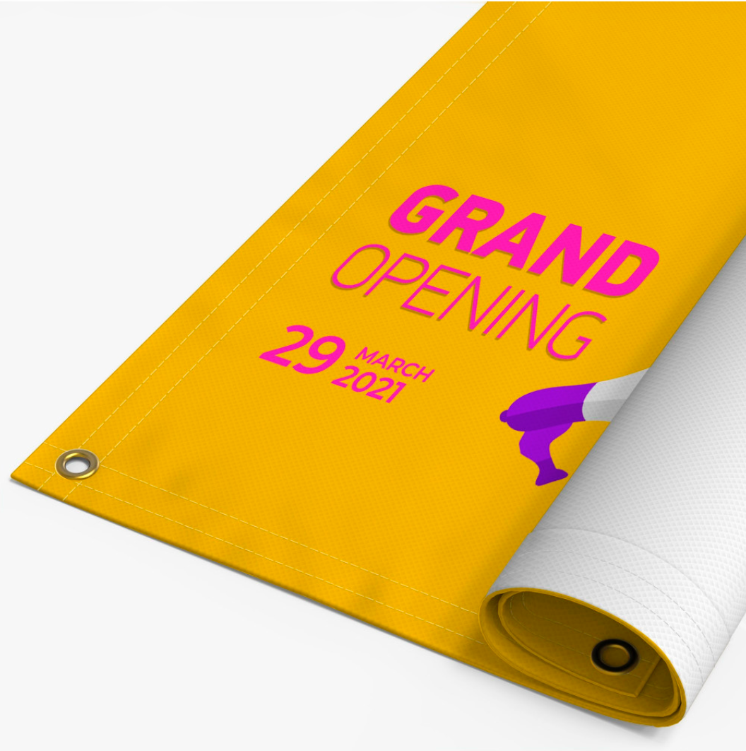 Yellow grand opening banner with pink text, rolled up, showing grommet.