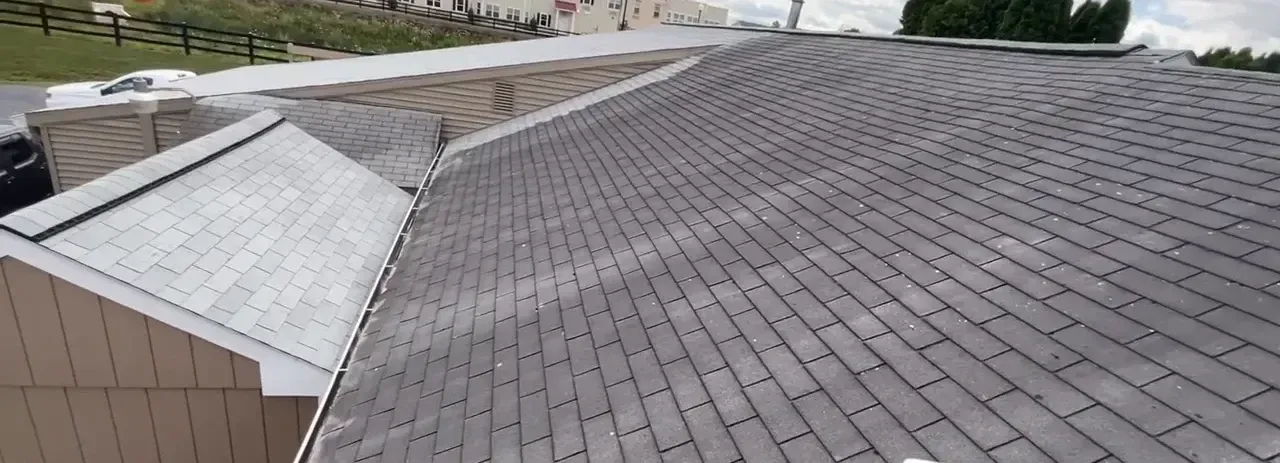 View of a gray shingle roof on a house with white trim.