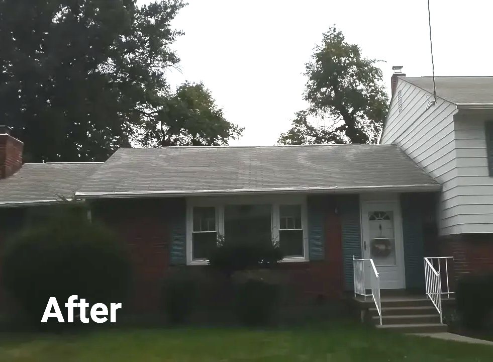 After: A house with a gray roof, white trim, and a small front yard on an overcast day.