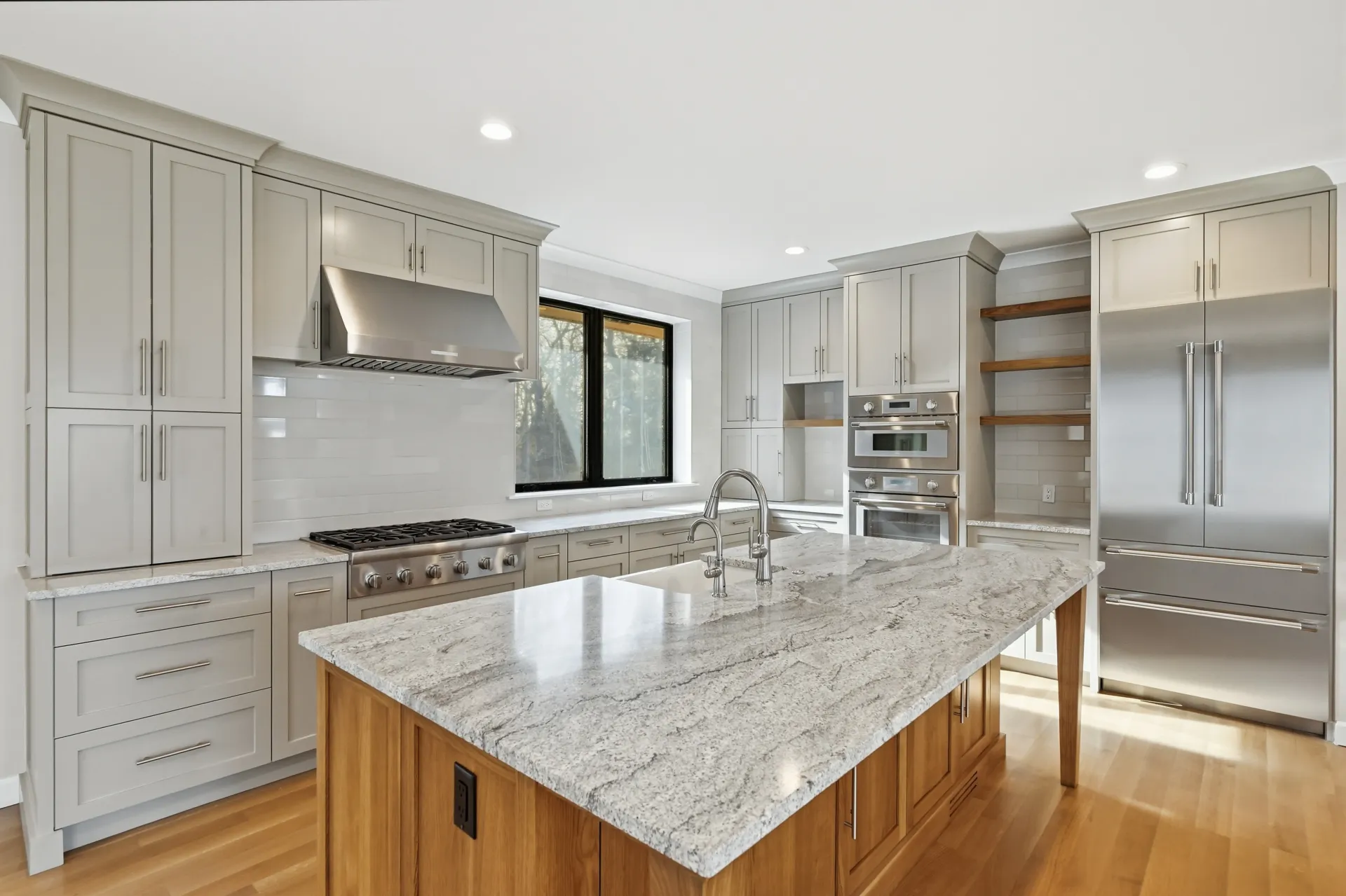 A kitchen with white cabinets and a black counter top - Omaha, NE - BluePrint Construction