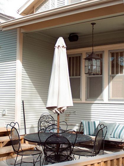 A porch with a table and chairs and an umbrella - Omaha, NE - BluePrint Construction