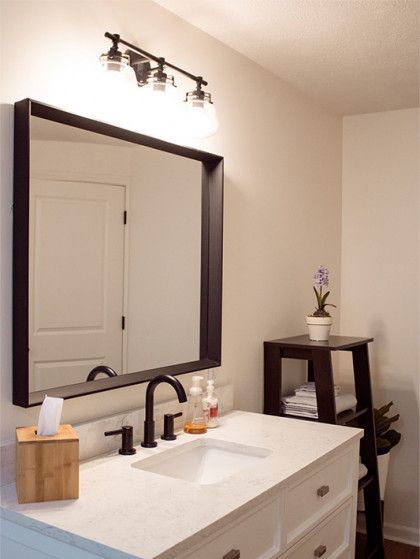 A bathroom with a sink and a large mirror - Omaha, NE - BluePrint Construction
